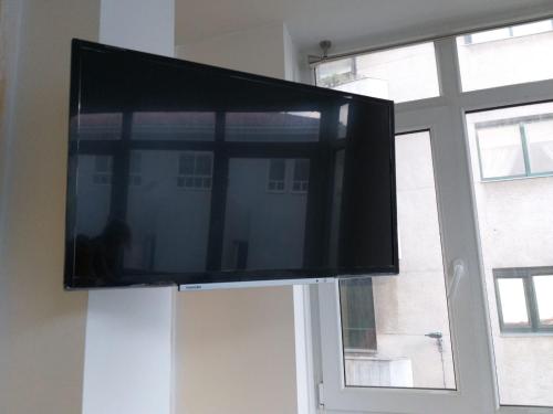 a flat screen tv sitting on top of a window at Apartamento en Ribeira(centro) 1*planta in Ribeira