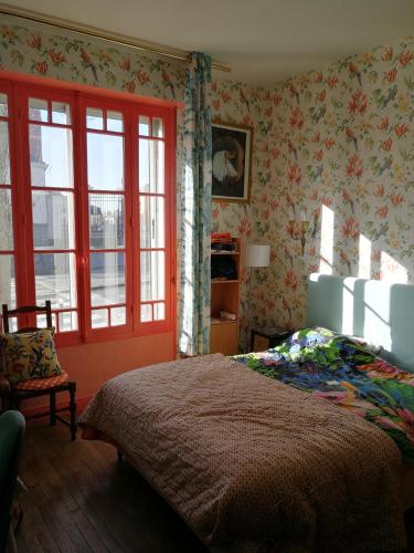 - une chambre avec un lit et du papier peint floral dans l'établissement Domaine Au charme des Plantes, à Rennes