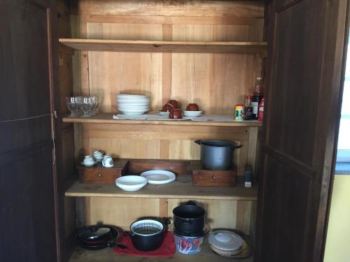 una estantería de madera con tazones y platos. en Luminoso Bilocale, en Magnano