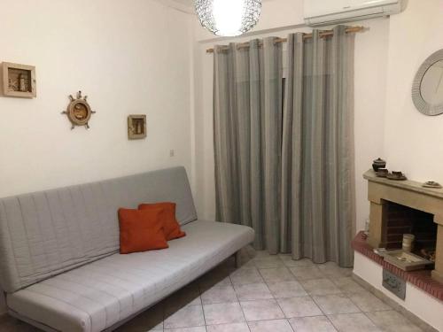 un sofá con una almohada naranja en la sala de estar en Harmony Apartment, en Kallithea Halkidikis