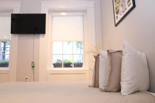 1 dormitorio con 1 cama con almohadas y TV en Downtown Beacon Hill, Convenient, Comfy Studio #1, en Boston
