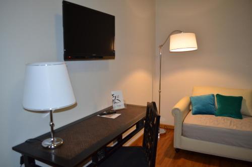 a living room with a desk and a couch and a lamp at Hotel Giglio in Montecatini Terme