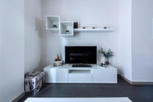 ein weißes Wohnzimmer mit einem TV an einer weißen Wand in der Unterkunft tuGuest Violeta's Home in Granada