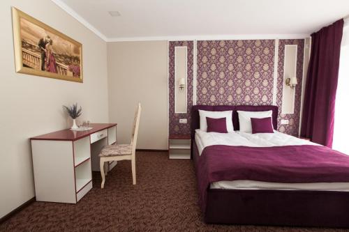 a bedroom with a bed and a desk and a chair at Mon Ami Hotel in Ivano-Frankivsʼk