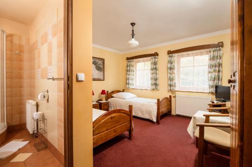 a hotel room with two beds and a television at Chata Cyborga in Stronie Śląskie