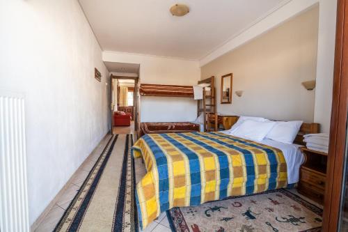 a bedroom with a bed with a yellow and blue blanket at Holiday Zigos in Igoumenitsa
