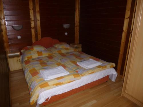 a bed with towels on it in a room at Rigófészek Vendégház in Mátraszele