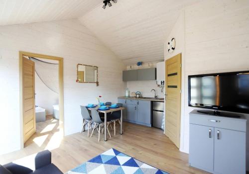 una cucina con un tavolo e una tv in una stanza di DOMKI WYPOCZYNKOWE ZOSIA I HELENKA a Puck
