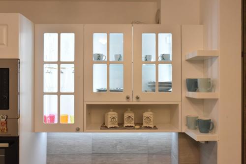 una cucina con mobili bianchi e ante in vetro di Zlatibor M a Zlatibor