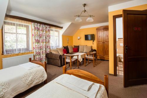 a hotel room with two beds and a living room at Chata Cyborga in Stronie Śląskie