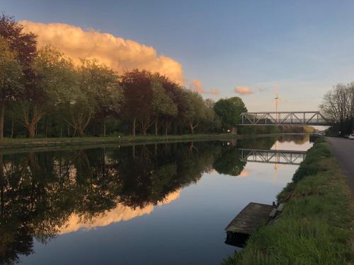 a view of a river with a bridge in the background at Villa van Brienen in Dilsen-Stokkem