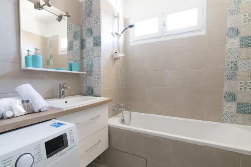 La salle de bains est pourvue d'une baignoire, d'un lavabo et d'un lave-linge. dans l'établissement A 2 pas du Palais free parking, à Avignon