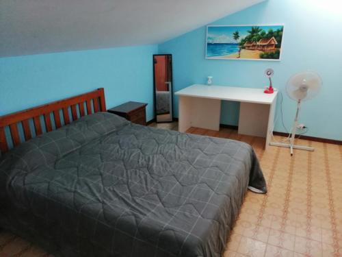 1 dormitorio con cama y escritorio blanco en Beach House, en Torvaianica