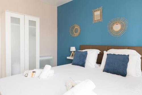 a bedroom with two beds with blue walls at A 2 pas du Palais free parking in Avignon
