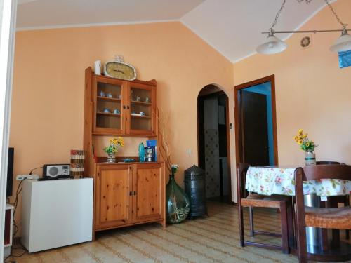 un soggiorno con tavolo e frigorifero bianco di Beach House a Torvaianica