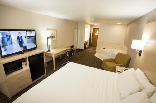 a hotel room with a bed and a flat screen tv at Best Western Watertown in Watertown
