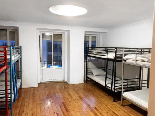 Pokój z 3 łóżkami piętrowymi i korytarzem w obiekcie Auristelas Hostel w Lizbonie