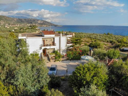 una vista aérea de una casa con el océano en el fondo en Paradeisos en Kardamyli