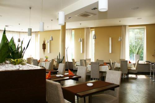 jadalnia ze stołami i krzesłami w restauracji w obiekcie Hotel Lions Plzen w Pilznie