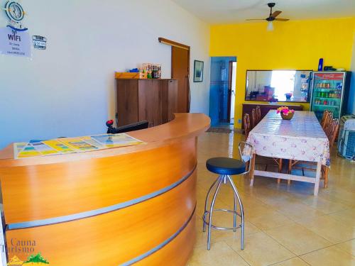 a kitchen with a counter and a table with a dining room at Pousada Cauna in Caraguatatuba