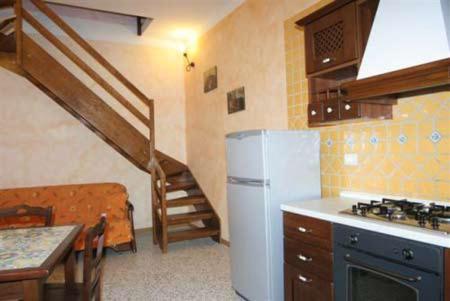 a kitchen with a refrigerator and a staircase in a room at Casa Di Nonna Pina in Marina di Camerota