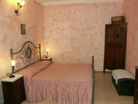 Casa Di Nonna Pina في مارينا دي كاميروتا: غرفة نوم مع سرير وخزانة