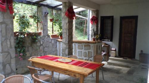 a wooden table and chairs in a room with windows at Villa Doina in Voronet