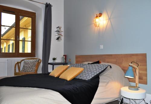 1 dormitorio con cama, lámpara y ventana en SEJOURAIXLESBAINS - Appartements Confidence hyper centre calme, en Aix-les-Bains