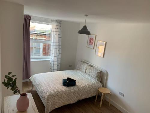 a bedroom with a bed with a bag on it at GRANBY APARTMENTS F-3 in Leicester
