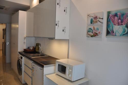 a small kitchen with a microwave on a counter at Valencia Town Center New Apartments in Valencia