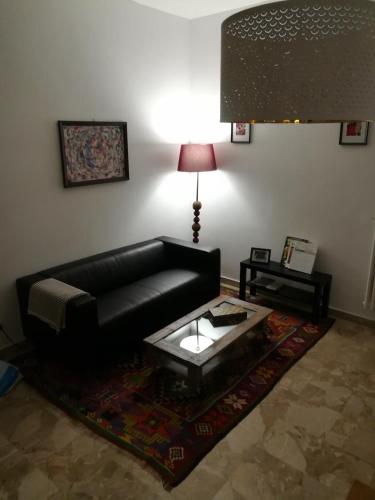 a living room with a black leather couch and a table at B&B La Terrazza Near The Beach in Bari