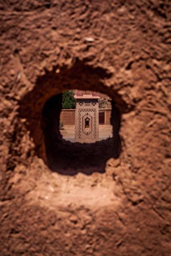 a hole in a rock with a small building in it at Kasbah Ait Kassi in Boumalne