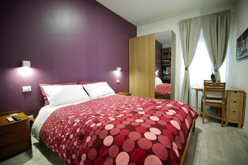 Schlafzimmer mit einem roten und weißen Bett und einem Fenster in der Unterkunft Posada de Liz y Fabrizio in Rom
