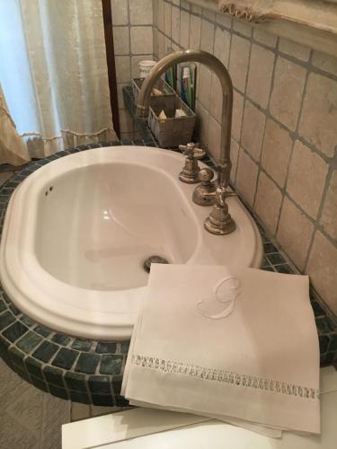 ein weißes Waschbecken im Bad mit Papier darauf in der Unterkunft RESIDENZA CarloMaria in Seregno