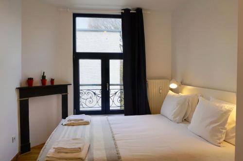 um quarto com uma cama grande e uma janela em Charming Apartments near Avenue Louise em Bruxelas