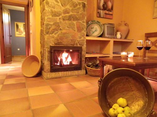 a living room with a fireplace and a table at Hotel Apartamento Rural Finca La Media Legua in Aracena