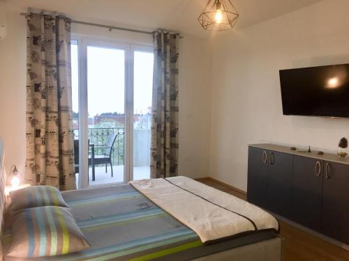 a bedroom with a bed and a sliding glass door at Aparthotel Monterria in Bar