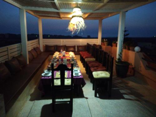 une salle à manger avec une table et des chaises sur une terrasse dans l'établissement ITRANE GUEST HOUSE, à Mirleft