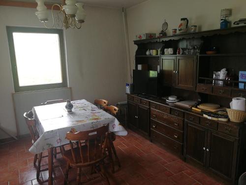 席洛的住宿－Ecohouse Oliveglia，厨房配有桌椅和电视。