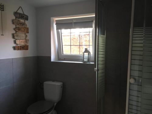 Un baño con inodoro y ventana. en BIG CALM APART HOTEL 15min WARSAW 6pers WiFi Fireplace Garden Grill, en Varsovia