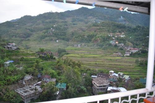 a view from a balcony of a village and a mountain at Banaue Homestay in Banaue