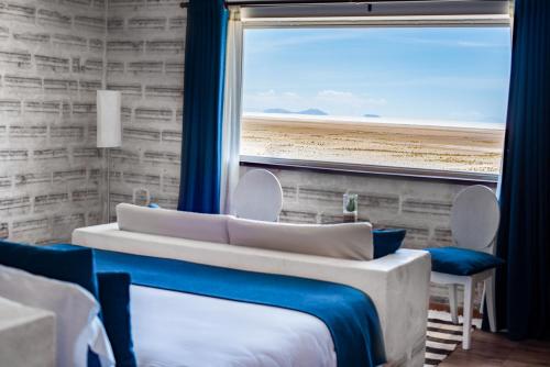 a bedroom with two beds and a large window at Hotel de Sal Luna Salada in Colchani