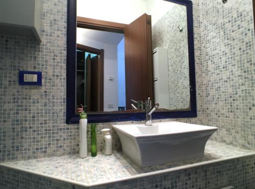 a bathroom with a sink and a large mirror at La casa di ringhiera in Milan