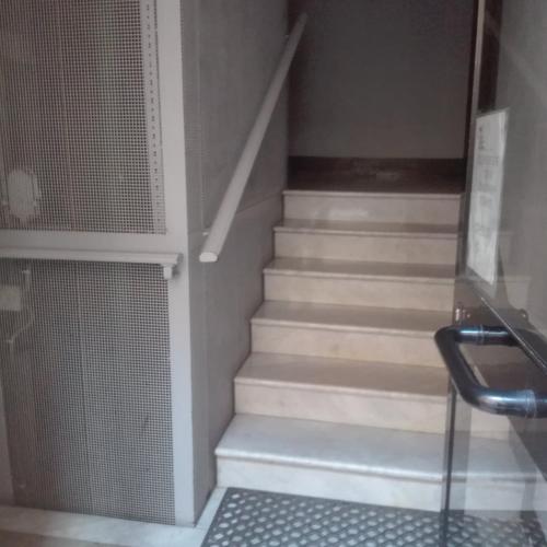 a set of stairs in a room with a glass door at La casetta di nonno Vittorio in Albissola Marina