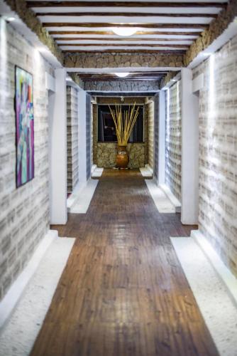 a long hallway with a brick wall and a vase at Hotel de Sal Luna Salada in Colchani