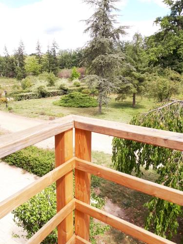 una terraza de madera con vistas al jardín en Les Mesangeres, en Chaumont-sur-Tharonne