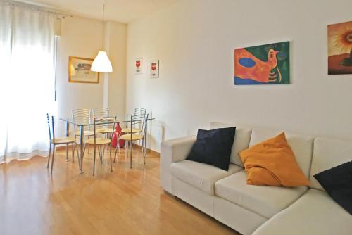 een woonkamer met een bank en een tafel en stoelen bij Lario Home in Milaan