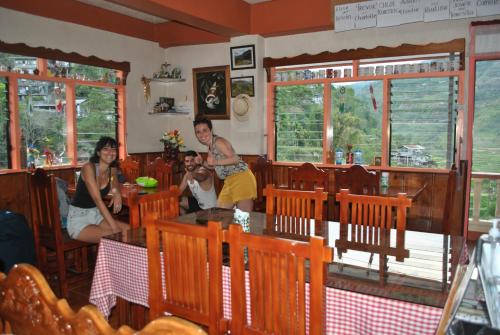 un grupo de personas sentadas en un restaurante en Banaue Homestay, en Banaue