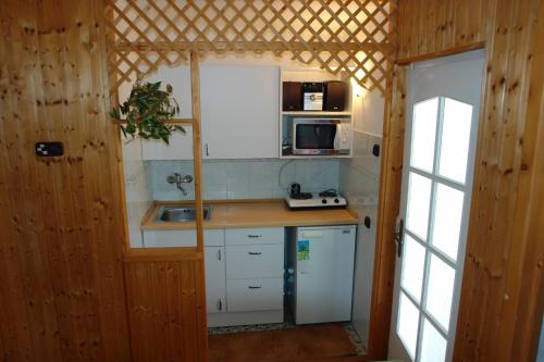 uma pequena cozinha com armários brancos e um lavatório em Mecsek üdülő ingyenes klímával 300 m-re a fürdőtől em Harkány