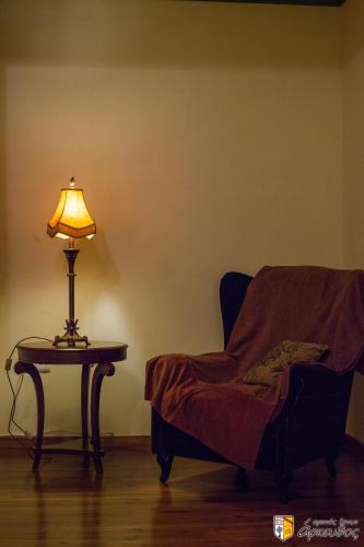 a lamp sitting on a table next to a chair at Arkefthos Mountain Hotel in Papigko